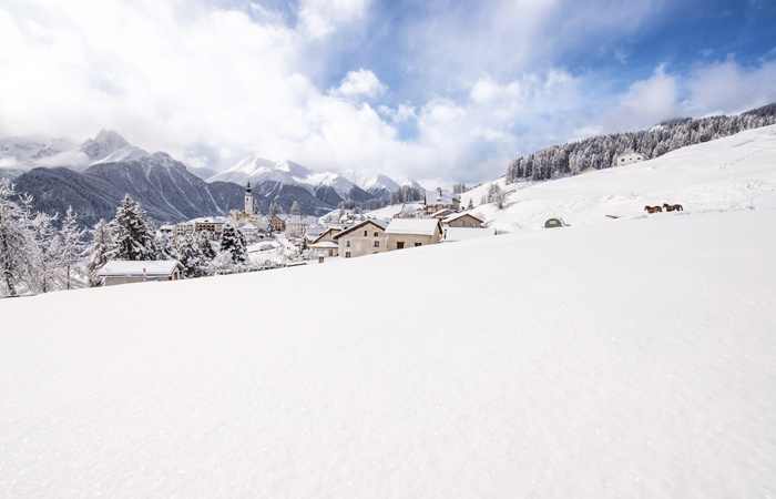Graubunden-village-snowy-blue-skiers