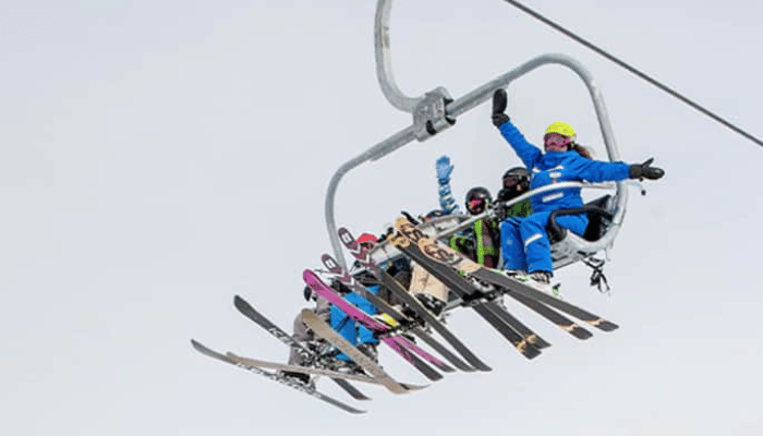 A group ski holiday taking a ski lift