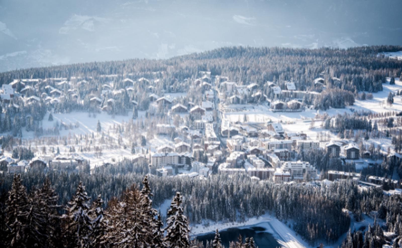 The ski resort of Crans Montana nestled amongst the snowy trees in the Swiss mountains
