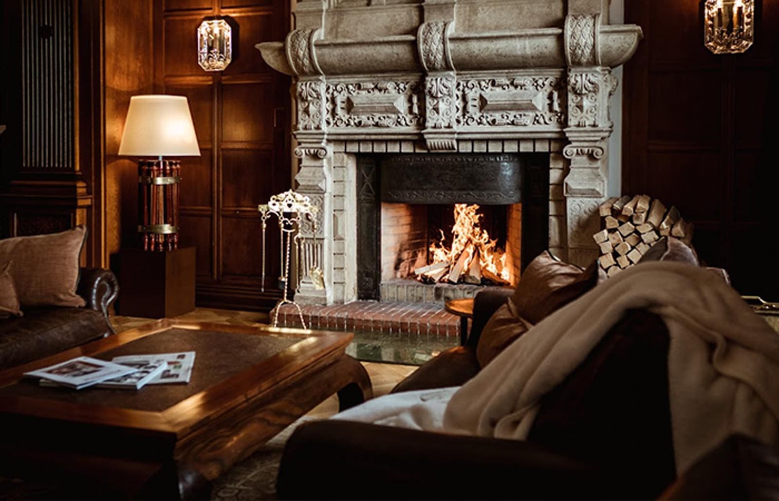 The cosy fireplace and surrounding armchairs at the Trutz in the ski resort of St. Moritz
